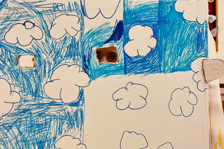 Illustration of clouds in a blue sky with child peeping through hole